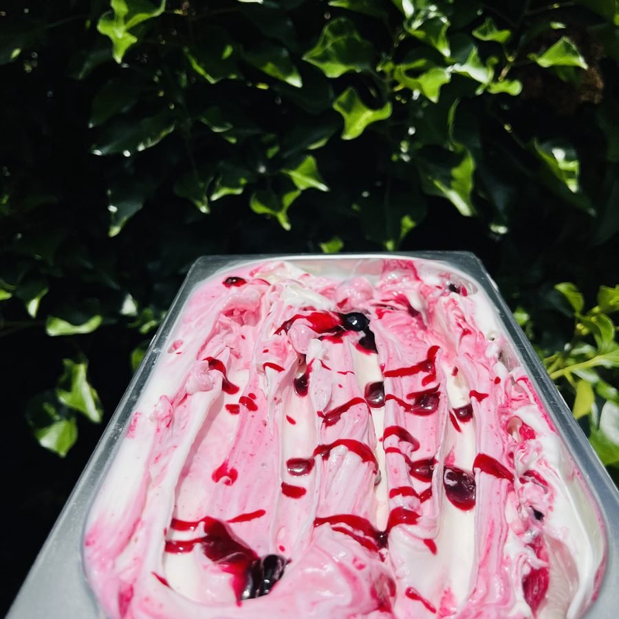 Een bak ijs met frambozenswirl, buiten in de zon